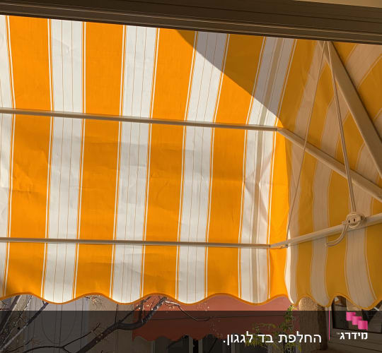 סוכך פסים צהוב ולבן עם מסגרת מתכת